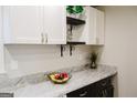 Close-up on a white countertop with granite, decor, and white cabinets at 710 Bluebird Se Dr, Conyers, GA 30094