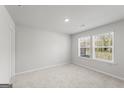Neutral bedroom featuring two windows, carpeted floors, and light gray walls at 77 Werner Brook Way Sw, Atlanta, GA 30354