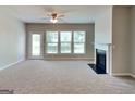 Bright living room featuring plush carpeting, fireplace, and multiple windows, creating a cozy and inviting space at 3741 Upland Dr, Mcdonough, GA 30253