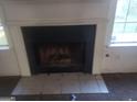 Close-up of the fireplace with white mantle, dark firebox, and tile hearth at 50 Village Walk, Covington, GA 30016