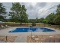 A sparkling in-ground pool with a concrete deck, surrounded by lush greenery and inviting lounge chairs at 245 Jewel Blf, Fayetteville, GA 30214