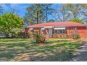 Well-kept brick home with awnings, landscaped front yard, and red metal roof at 111 Highway 138 E, Stockbridge, GA 30281