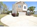 Attractive home showcasing a stone and siding exterior, an attached garage, and a well-maintained lawn at 116 Ducati Dr, Mcdonough, GA 30252