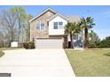 Two story home with stone facade, attached garage and landscaping in a well-manicured lawn at 116 Ducati Dr, Mcdonough, GA 30252