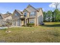 Well-maintained two-story home with a manicured lawn and a two-car garage on a sunny day at 6870 Diamond Dr, Rex, GA 30273