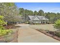 Well-maintained home with lush landscaping and a long driveway leading to the attached garage at 410 Denton Cir, Fayetteville, GA 30215