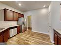 Well-equipped kitchen with stainless steel appliances, granite countertops, wood cabinets, and stylish wood-look flooring at 3713 Upland Dr, Mcdonough, GA 30253