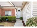 Inviting front entrance with sidelight and arched window, surrounded by manicured greenery at 116 Evenview Dr., Jonesboro, GA 30236