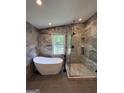 Beautiful bathroom featuring a soaking tub, large glass shower, and modern fixtures, complemented by elegant marble walls at 281 New Hope Dr, Mcdonough, GA 30252
