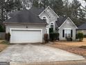 Two-story home featuring a gray exterior, arched windows, and an attached two-car garage at 204 Clifton Ln, Peachtree City, GA 30269