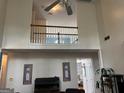 Bright living room with a tall ceiling, view to second floor hallway, and plants at 233 Mistybrook Cir, Stone Mountain, GA 30087