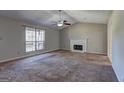 Spacious living room featuring a fireplace, carpet flooring, vaulted ceiling, and lots of natural light at 130 Bradley Pl, Mcdonough, GA 30253