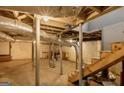 Unfinished basement featuring exposed piping, support beams, a staircase, and concrete flooring at 627 S Elizabeth Nw Pl, Atlanta, GA 30318