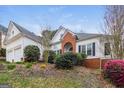 Exterior view of a home featuring a two-car garage and landscaped front yard at 364 Valleyside Dr, Dallas, GA 30157