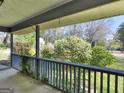 Inviting covered porch overlooking a lush garden with mature trees and greenery at 1001 Stagecoach Rd, Stockbridge, GA 30281