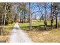 Scenic gravel driveway leading to a home surrounded by trees and lush greenery at 640 Lovell Rd, Temple, GA 30179