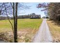 A beautiful home nestled on a large lot, showcasing a long driveway and detached garage at 640 Lovell Rd, Temple, GA 30179