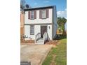 Traditional two-story townhouse with a small front yard and concrete parking area at 2047 Charter Ln, Lithonia, GA 30058