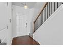 Inviting entryway features hardwood floors, staircase with wood railing, and modern light fixture at 813 Royal Red Ct, Mcdonough, GA 30253