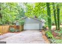 Detached two-car garage with a spacious driveway, nestled in a wooded lot at 346 Buckingham Sw Dr, Conyers, GA 30094