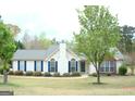 Charming one-story home with blue shutters and well-manicured lawn at 329 Harris Ave, Locust Grove, GA 30248