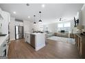 Open-concept kitchen and living room with hardwood floors and plenty of natural light at 807 Stickley Oak Way, Woodstock, GA 30189