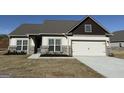 A lovely single Gathering home with a large two-car garage, white and brown siding, and neatly trimmed landscaping at 661 Cantrell Drive, Dallas, GA 30157