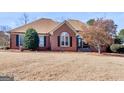 Charming brick home featuring a lawn of dry dormant grass and appealing landscaping at 200 Magnolia Ct, Mcdonough, GA 30252