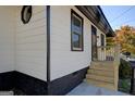 Stylish home exterior featuring white horizontal siding with black trim, a small porch, and a well-maintained foundation at 34 Ivy St, Porterdale, GA 30014