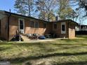 Spacious backyard patio with chairs and table, adjacent to the brick home and a large grassy area at 4063 Windsor Castle Way, Decatur, GA 30034