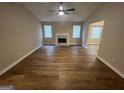 Open living room showcasing hardwood floors, a fireplace, and large windows at 260 Countryside Ln, Covington, GA 30016