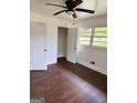 Bright bedroom features hardwood floors, a window view, and closet space at 1322 S Hicks Cir Nw, Conyers, GA 30012