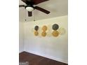 Stylish wall decor enhances the room's aesthetic, complemented by a ceiling fan and warm lighting at 1322 S Hicks Cir Nw, Conyers, GA 30012