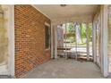 Enclosed porch with brick wall, vintage flooring, and an open view to the backyard, perfect for relaxation at 2255 Beecher Sw Rd, Atlanta, GA 30311