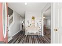 Inviting foyer featuring wood-look flooring, a console table, a staircase, and light gray walls at 520 Easton Dr, Locust Grove, GA 30248