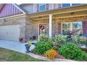 Beautifully landscaped front entrance with a covered porch, perfect for enjoying the outdoors at 1058 Hartwell Rd, Locust Grove, GA 30248