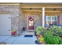 Inviting covered front porch with decorative wreath and potted plants provides a warm welcome at 1058 Hartwell Rd, Locust Grove, GA 30248
