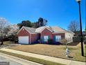 Charming one-story red brick home with well-manicured lawn, flowering trees, and a two-car garage at 325 Autumn Glen Cir, Fayetteville, GA 30215