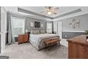 Spacious bedroom with tray ceiling, carpet flooring, and windows with natural light at 1022 Miss Amber Way, Locust Grove, GA 30248