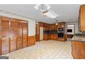 A retro kitchen featuring wood cabinetry, a spacious layout, and classic tile flooring adds a touch of nostalgia at 426 Old Senoia Rd, Fayetteville, GA 30215