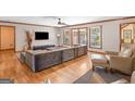 A stylish living room boasts hardwood floors, a large sectional sofa, and views of the outdoor space at 426 Old Senoia Rd, Fayetteville, GA 30215