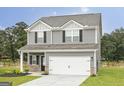 Charming two-story home featuring gray siding, black shutters, and a two-car garage at 301 Limestone Circle, Conyers, GA 30013