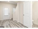 Bright foyer with wood-look flooring, stairs to the left, and white doors at 301 Limestone Circle, Conyers, GA 30013