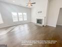 Bright living room featuring hardwood floors, a cozy fireplace, and large windows providing ample natural light at 3695 Andover St, Cumming, GA 30028