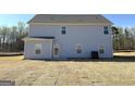 Backyard view of the two-story home with light blue siding, patio, and a well-manicured lawn at 685 Cantrell Drive, Dallas, GA 30157