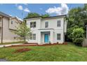 Well-manicured front yard with a two-story home that has an inviting bright blue front door at 1188 Oakland Sw Ln, Atlanta, GA 30310