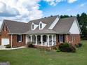 Beautifully landscaped front yard with brick home and white trim at 557 Arrowhead Cir, Rutledge, GA 30663
