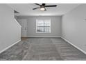 Bright living room with a ceiling fan, plush carpet, and neutral paint creates an inviting and comfortable space at 6566 Chestnut Oaks Rdg, Lithonia, GA 30038