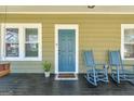 Relaxing front porch with rocking chairs, plants, a welcome mat, and a painted wood floor at 988 Allene Sw Ave, Atlanta, GA 30310