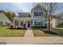Inviting home exterior featuring a covered front porch, meticulous landscaping, and a light green facade at 509 Cowpens Rd, Social Circle, GA 30025